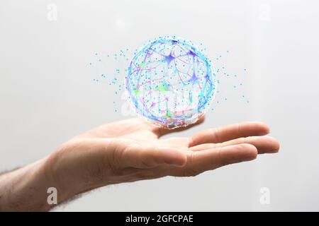 Hand holding a digital illustration of an interconnected network of lines forming a globe Stock Photo