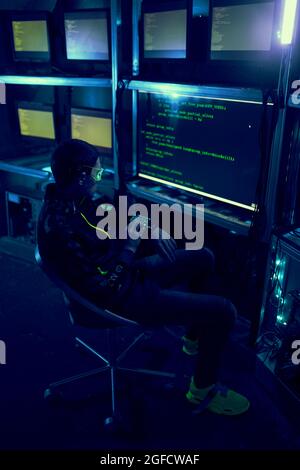 Cyber hacker breaks into databases to obtain information using a computer. Cybercrime and data security concept. Stock Photo