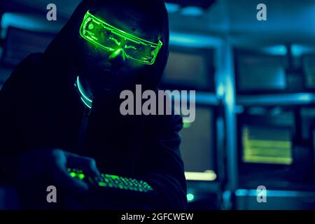 Cyber hacker breaks into databases to obtain information using a computer. Cybercrime and data security concept. Stock Photo