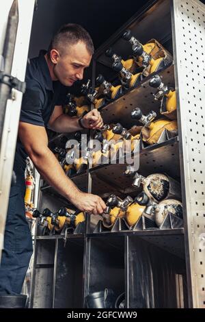 Fireman checking fire extinguisher in truck Stock Photo