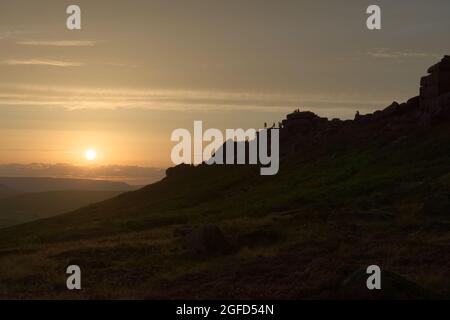 Wide angle sunset at stanage edge. Many people pursue outdoor recreational activities on top of the rocky edge. Dramatic and popular landmark Stock Photo