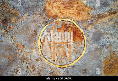 Rusty helipad at abandoned mine over rough stone surface, aerial view directly above. Dystopic post apocalyptic texture Stock Photo