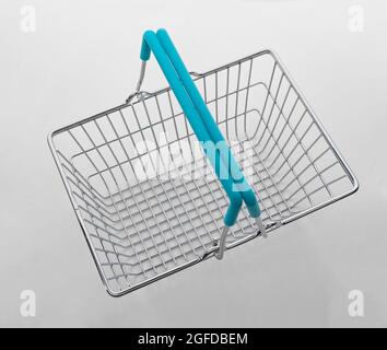 Metal wire shopping basket looking down from above on neutral grey background Stock Photo