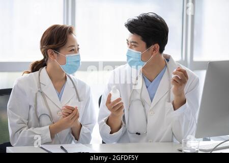 Young doctors using hand sanitizer in doctor's office Stock Photo