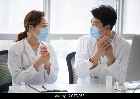 Young doctors using hand sanitizer in doctor's office Stock Photo