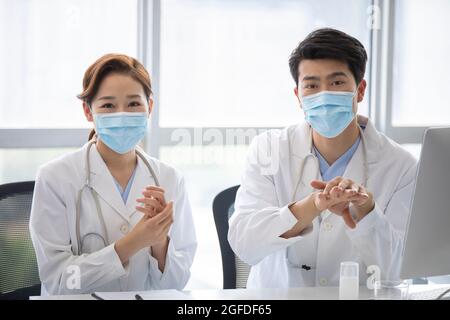 Young doctors using hand sanitizer in doctor's office Stock Photo