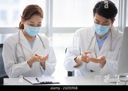 Young doctors using hand sanitizer in doctor's office Stock Photo