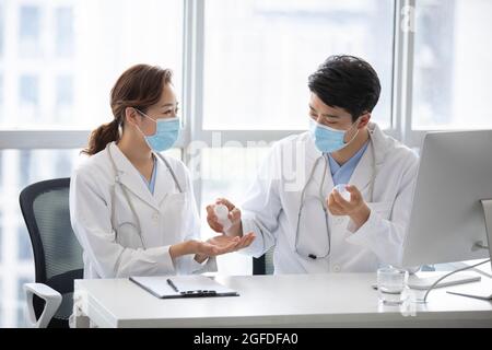 Young doctors using hand sanitizer in doctor's office Stock Photo