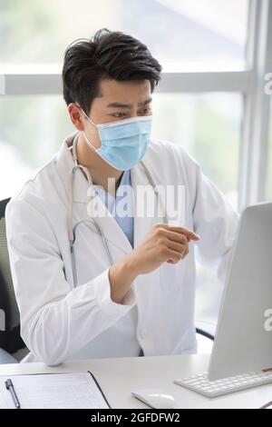 Young doctor using computer in doctor's office Stock Photo