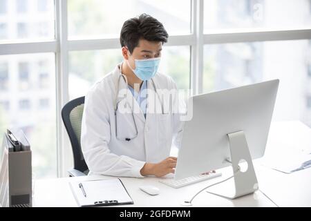 Young doctor using computer in doctor's office Stock Photo