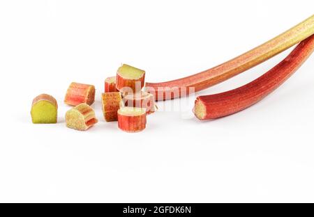 Rhubarb stalks and cut pieces of rhubarb on white background Stock Photo