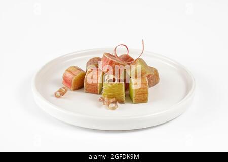 Cut fresh rhubarb on white plate Stock Photo