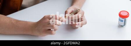 cropped view of ill man holding joint with medical cannabis, banner Stock Photo