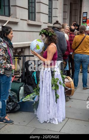 London, UK - 25 Aug 2021, A protestor gets ready with her costume during a protest outside the Brazilian Embassy in London.Protestors gathered outside the Brazilian Embassy in London to call for an end to the genocidal attacks being waged against Brazil's indigenous peoples. Supporters of Amazon Rebellion, Brazil Matters, CAFOD, Greenpeace, Parents for Future and Survival International will protest to stop Brazilian Genocide as part of the “Struggle for Life” (“Luta pela Vida”) global action led by the Association of Indigenous Peoples of Brazil (APIB). Stock Photo