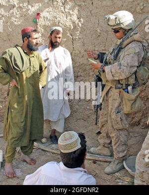 Daniel B. Wyss, a squad leader with Golf Company, 2nd Battalion, 9th Marine Regiment, collects information from local Afghans during a census operation, Aug 16, in Marjah. The squad came under attack halfway through the patrol, and engaged enemy Taliban in the process. Wyss is from Pontiac, Mich. Stock Photo