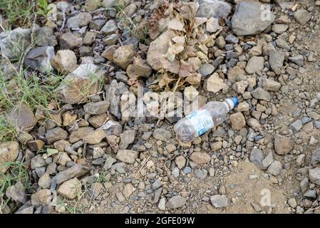 RIUDECANYES, SPAIN - Aug 07, 2021: A closeup shot of trash scattered around in open nature in Riudecanyes, Spain Stock Photo