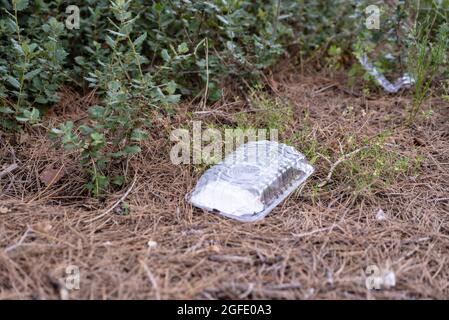 RIUDECANYES, SPAIN - Aug 07, 2021: A closeup shot of trash scattered around in open nature in Riudecanyes, Spain Stock Photo