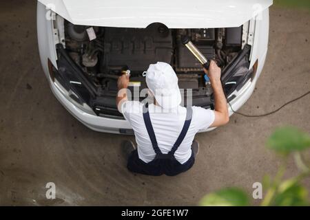 Top view rear view shot of a car mechanic repairing engine of an auto Stock Photo