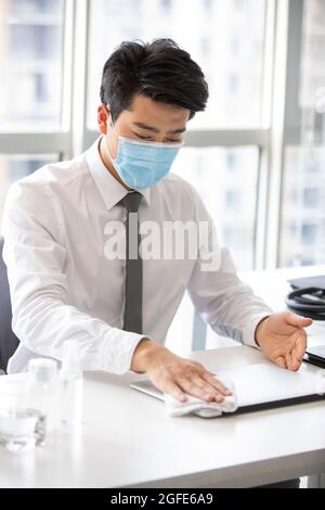 Young businessman using disinfectant in office Stock Photo
