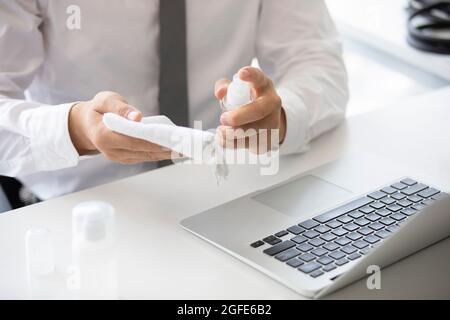 Young businessman using disinfectant in office Stock Photo