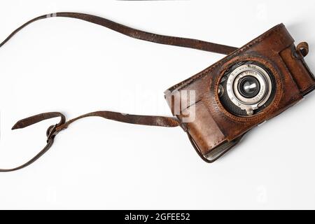 Old vintage camera with 35mm lens in brown leather case isolated on white background Stock Photo