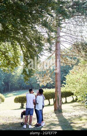 Happy young friends toasting beer bottles in garden Stock Photo