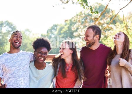 Portrait of smiling young friends standing in park Stock Photo