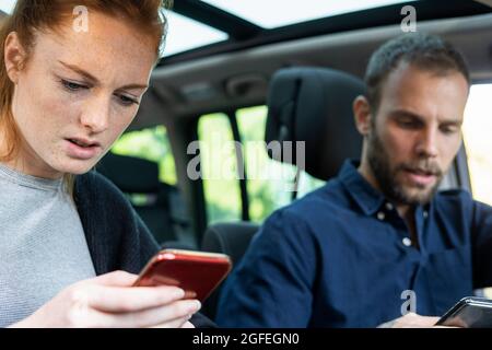 Anxious young couple using smart phones Stock Photo