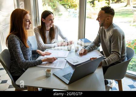 Smiling young friends studying at home Stock Photo