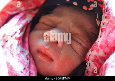 Beautiful baby boy a few seconds after the birth. Baby after birth. Stock Photo