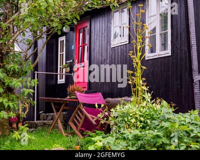 Thorshavn, Faroe Islands - October 2020: Small garden next to a typical turf house in Torshavn on Streymoy Island. Old Town of Torshavn, Faroe Islands Stock Photo