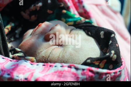 Beautiful baby boy a few seconds after the birth. Baby after birth. Stock Photo