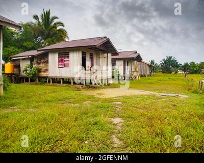 Mabul, West Papua, Indonesia - January 2015: Wooden houses on stilts in a small village built by the indonesian government for Korowai people. Asia Stock Photo