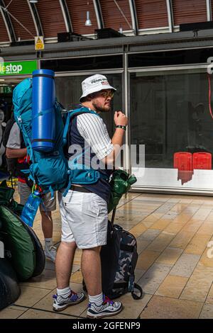 LONDON, UK. 25 August 2021.  Young festival goers with backpacks and camping gear prepare to depart from Paddington station for the 5 day Reading music festival.  Credit amer ghazzal/Alamy Live News Stock Photo