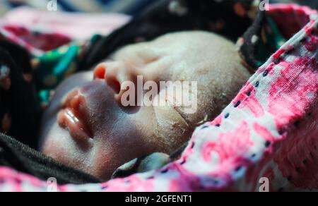 Beautiful baby boy a few seconds after the birth. Baby after birth. Stock Photo