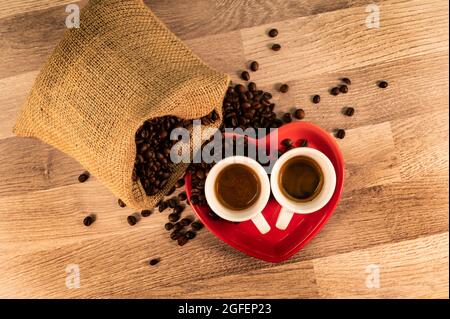 composition of coffee with grains and cups on wooden surface Stock Photo