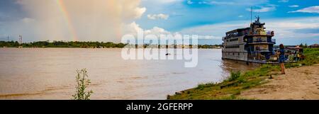 Amazon River, Peru - Dec, 2019: Panoramic view of slow boat 'Maria Fernanda' and rainbow in the small port on the Amazon River. Amazonia. South Americ Stock Photo