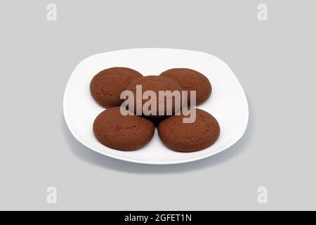 Oatmeal cookies on a white plate. Close-up. Isolated on a gray background. Stock Photo