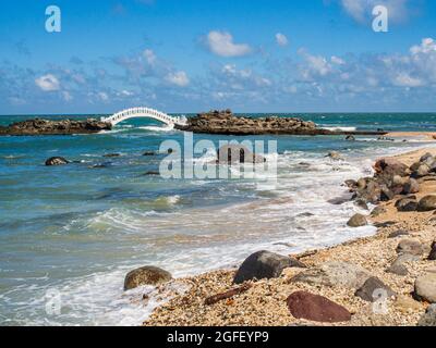 Shimen, Taiwan - October 03, 2016: A white bridge between the rocks on the shore of the ocean in Shimen Art, northern Taiwan Stock Photo