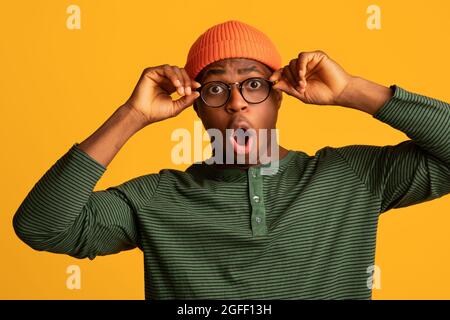 Amazed Shocked Young Black Guy Touching Glasses And Opening Mouth In Surprise Stock Photo