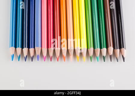 set of colored pencils lined up hardly on a white background Stock Photo
