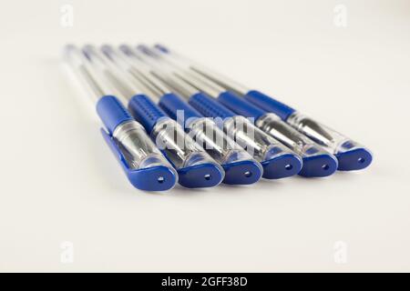 set of blue ballpoint pens lined up hardly on a white background Stock ...