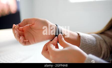 Hands of a woman who is putting on a watch Stock Photo