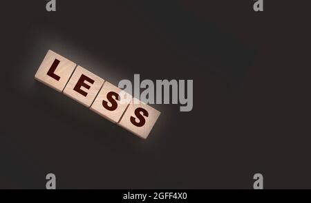 Less word on wooden cubic blocks. Spend less or cut costs business concept Stock Photo