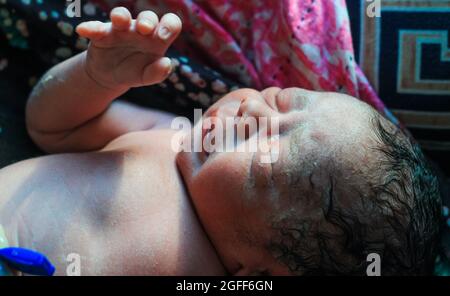 Beautiful baby boy a few seconds after the birth. Baby after birth. Stock Photo