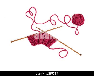 Knitting pattern on wooden needles of woolen threads red color isolated on white background Stock Photo