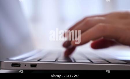 unrecognizable person types on laptop. Stock Photo