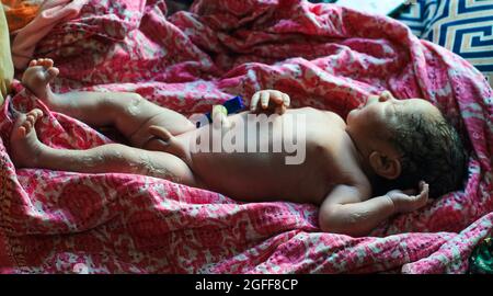 Beautiful baby boy a few seconds after the birth. Baby after birth. Stock Photo