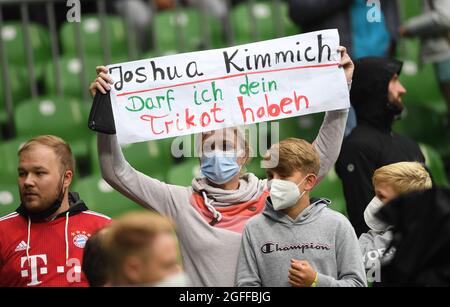 Bremen, Germany. 25th Aug, 2021. Football: DFB Cup, Bremer SV - Bayern Munich, 1st round, wohninvest Weserstadion. A woman holds up a poster and asks for Joshua Kimmich's jersey. Credit: Carmen Jaspersen/dpa - IMPORTANT NOTE: In accordance with the regulations of the DFL Deutsche Fußball Liga and/or the DFB Deutscher Fußball-Bund, it is prohibited to use or have used photographs taken in the stadium and/or of the match in the form of sequence pictures and/or video-like photo series./dpa/Alamy Live News Stock Photo