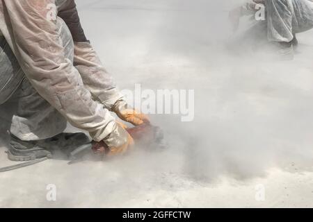 Hands of worker grinding concrete surface Stock Photo